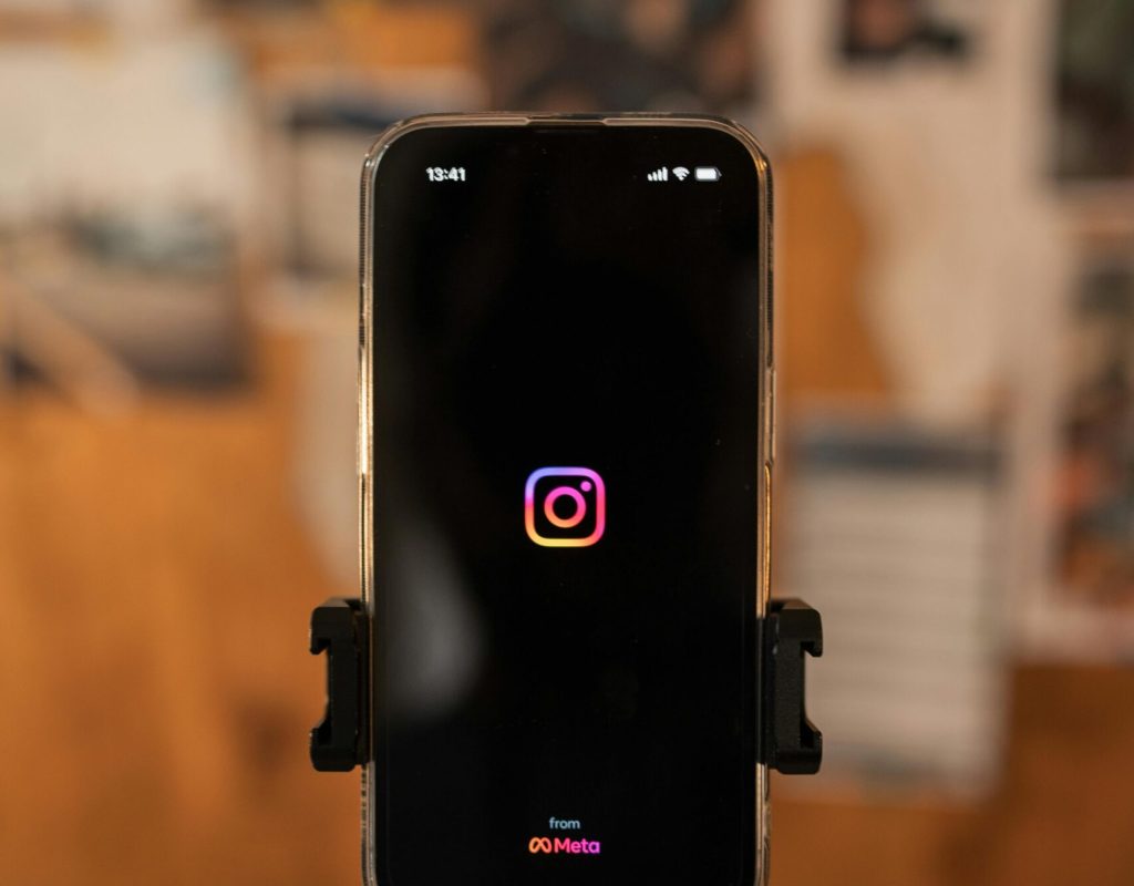 Smartphone displaying Instagram logo on tripod, perfect for social media concepts.