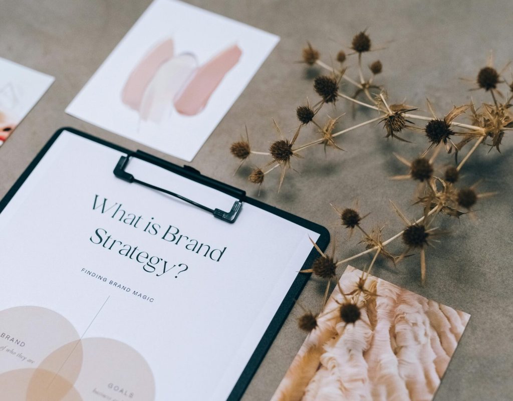 Elegant flat lay of branding strategy documents with a natural twig accent.